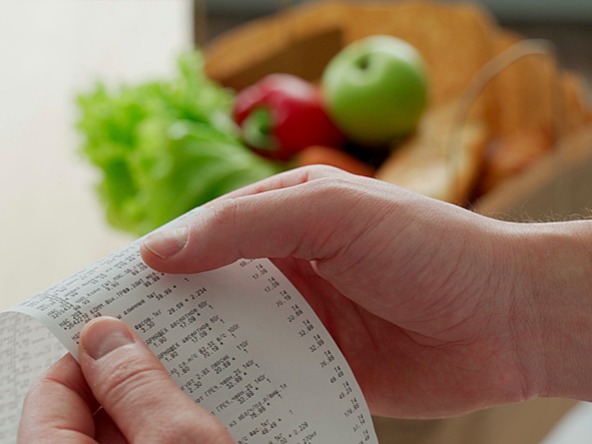 Person examining shopping receipt, indicative of the cost-of-living crisis